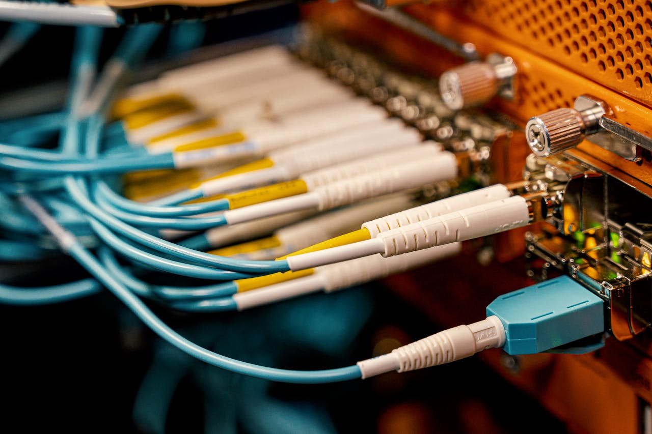 From above of optical switch equipment with many similar connectors with rubber cables and metal parts